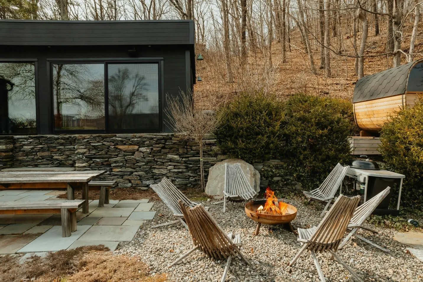 Polywood furniture around a fire pit in a rustic outdoor space.